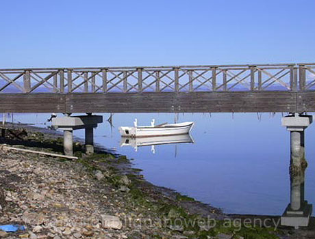 Eine Bruecke und ein Boot in Grado foto